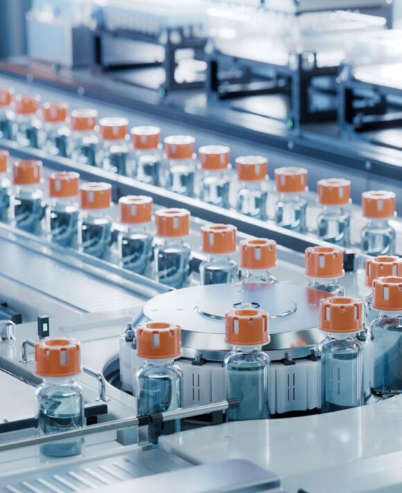 Pharmaceutical Medical Equipment Vaccine Production Facility. Medication Manufacturing Process. Glass Vials with Orange Caps on Conveyor Belt. Medical Ampoule Production Line at Modern Pharmaceutical Factory.